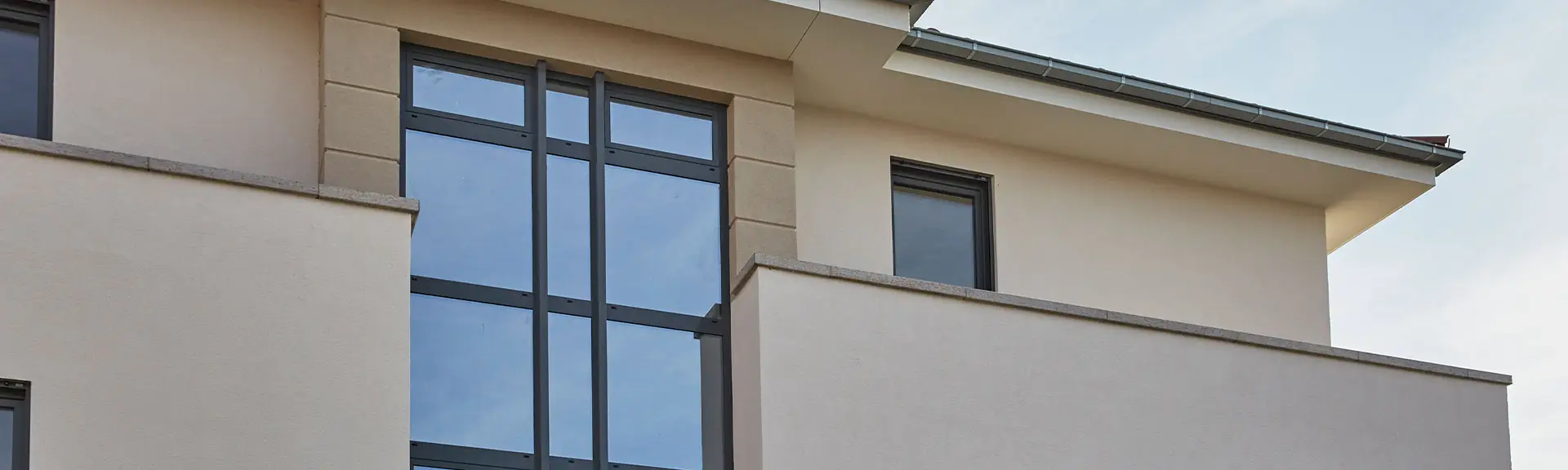 Nahaufnahme eines modernen Fensters mit schwarzem Rahmen in einer hellen Fassade